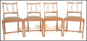 A set of four early 20th Century Arts and Crafts oak dining chairs retailed by Phillips of