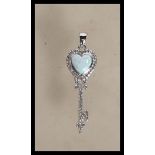 A Tiffany style key shape pendant having a heart shaped Opal surrounded with cz accent stones.