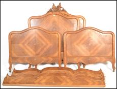 A pair of French walnut corbeille beds with carved foliate and flower decoration, quarter veneer