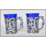 A pair of Art Deco style chrome Japanese decorated mug cup holders with dragon and floral