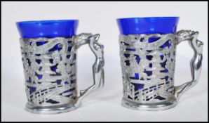 A pair of Art Deco style chrome Japanese decorated mug cup holders with dragon and floral