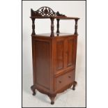 An early 20th Century Edwardian oak music cabinet of upright form having a Art Nouveau pierced