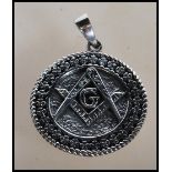 A stamped 925 silver necklace pendant of round form having a geometric pattern border around the