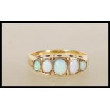 A 20th Century stamped 18ct gold ring set with five graduating oval opal cabochons. Weight 2.4g.