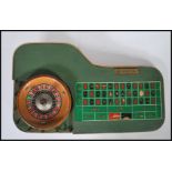 A vintage 1960's casino miniature roulette table having a spinning wheel and counter board with a