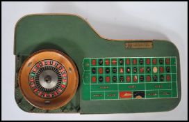 A vintage 1960's casino miniature roulette table having a spinning wheel and counter board with a