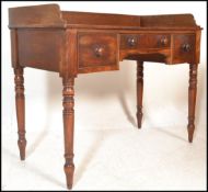 A 19th Century mahogany writing table desk, gallery surround to the flared top over three drawers
