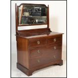 An early 20th Century mahogany dressing chest, swing mirror atop over flared top with three