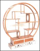 A 20th Century Chinese hardwood distressed etagere display room unit divider of circular form having