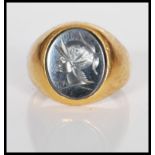 An unmarked 14ct gold signet ring set with an oval black stone to the head engraved with a cameo