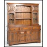 An Old Charm oak Linenfold dresser and rack, the rack with two lead glazed doors and two plate