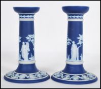 A pair of 19th Century Wedgwood navy blue dip jasperware candlesticks having raised white