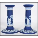 A pair of 19th Century Wedgwood navy blue dip jasperware candlesticks having raised white