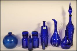 A collection of 20th Century blue glass items to include bulbous vase having a glazed effect, tall