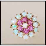 A hallmarked 9ct gold cluster ring set with round opal cabochons and round cut pink stones.