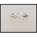 A hallmarked 18ct yellow gold ring having flowerhead mount set with a cluster of diamonds of