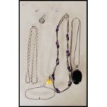A selection of silver necklaces to include a spacer necklace with purple beads, a snake chain