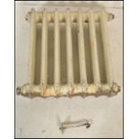 An early 20th Century two bar seven column cast iron radiator having a white paint finish.