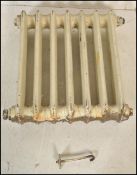 An early 20th Century two bar seven column cast iron radiator having a white paint finish.