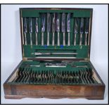 A large 20th Century wooden cased cutlery canteen having a fully appointed green felted interior