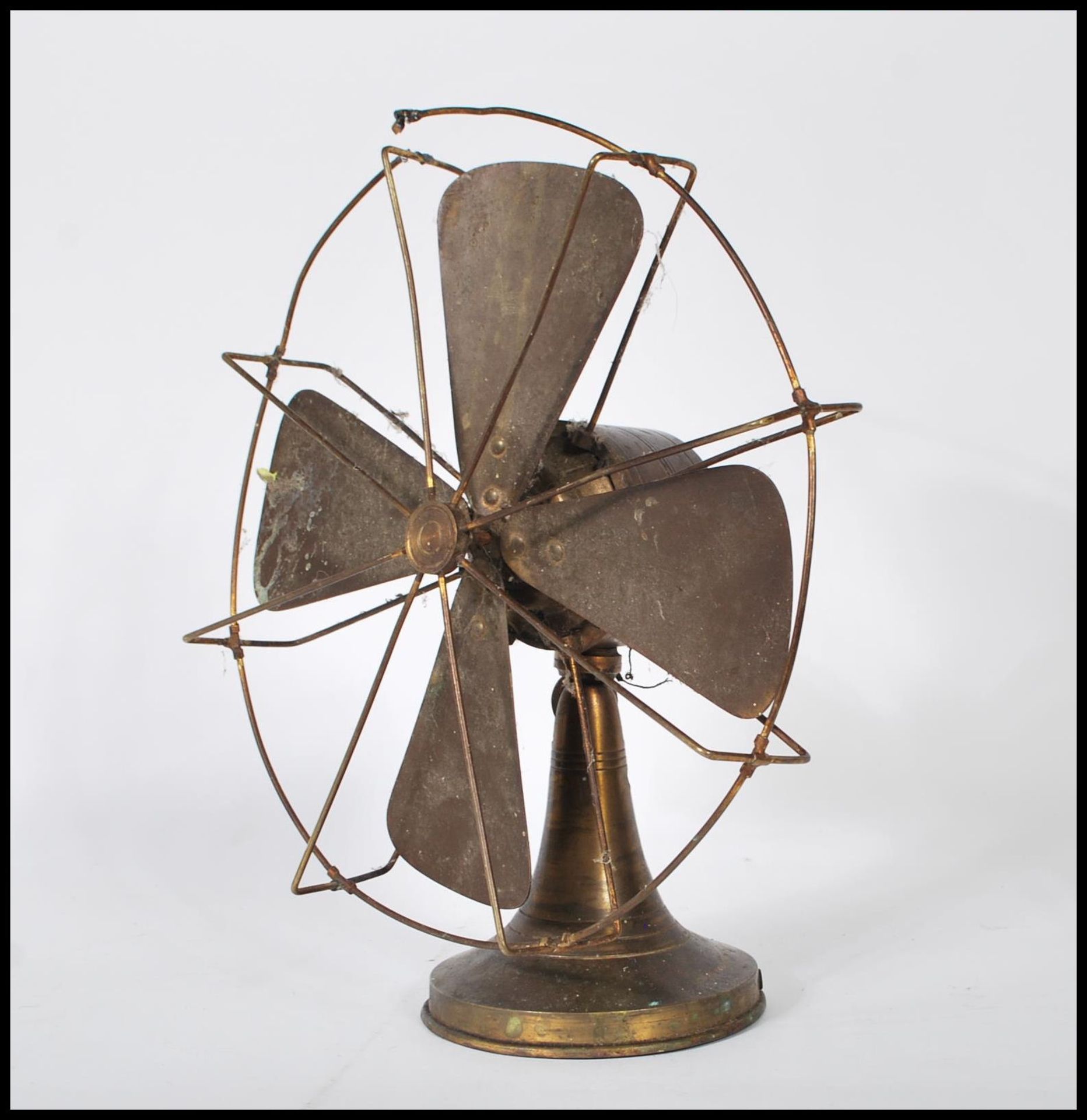 A vintage mid 20th Century 1940's industrial desk top table electrical fan raised on a circular base