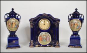 A early 20th Century English ceramic clock and garniture set by Empire ware. The central dial