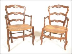 A pair of 20th Century French fruit wood Louis XV style elbow / fauteuil armchairs, serpentine