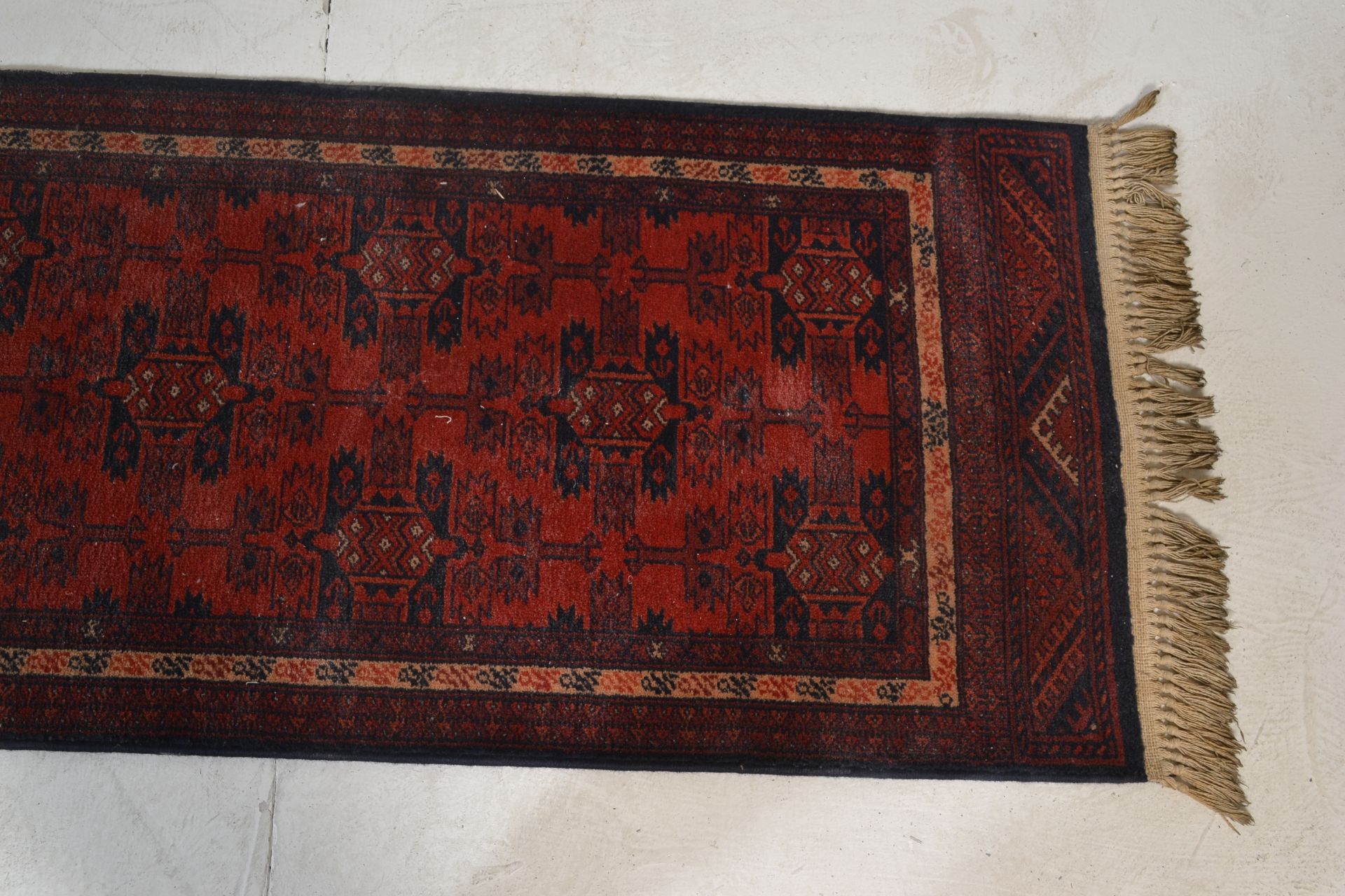 A Belgian Made ' Basra ' Tassled 'wool rug floor runner on red ground, central design of geometric - Bild 2 aus 4