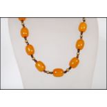 A vintage 20th Century butterscotch bakelite beaded necklace having brown bead spacers.