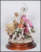 A large Capodimonte ceramic figure group depicting three figures depicting two women in draped