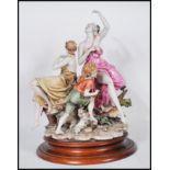 A large Capodimonte ceramic figure group depicting three figures depicting two women in draped