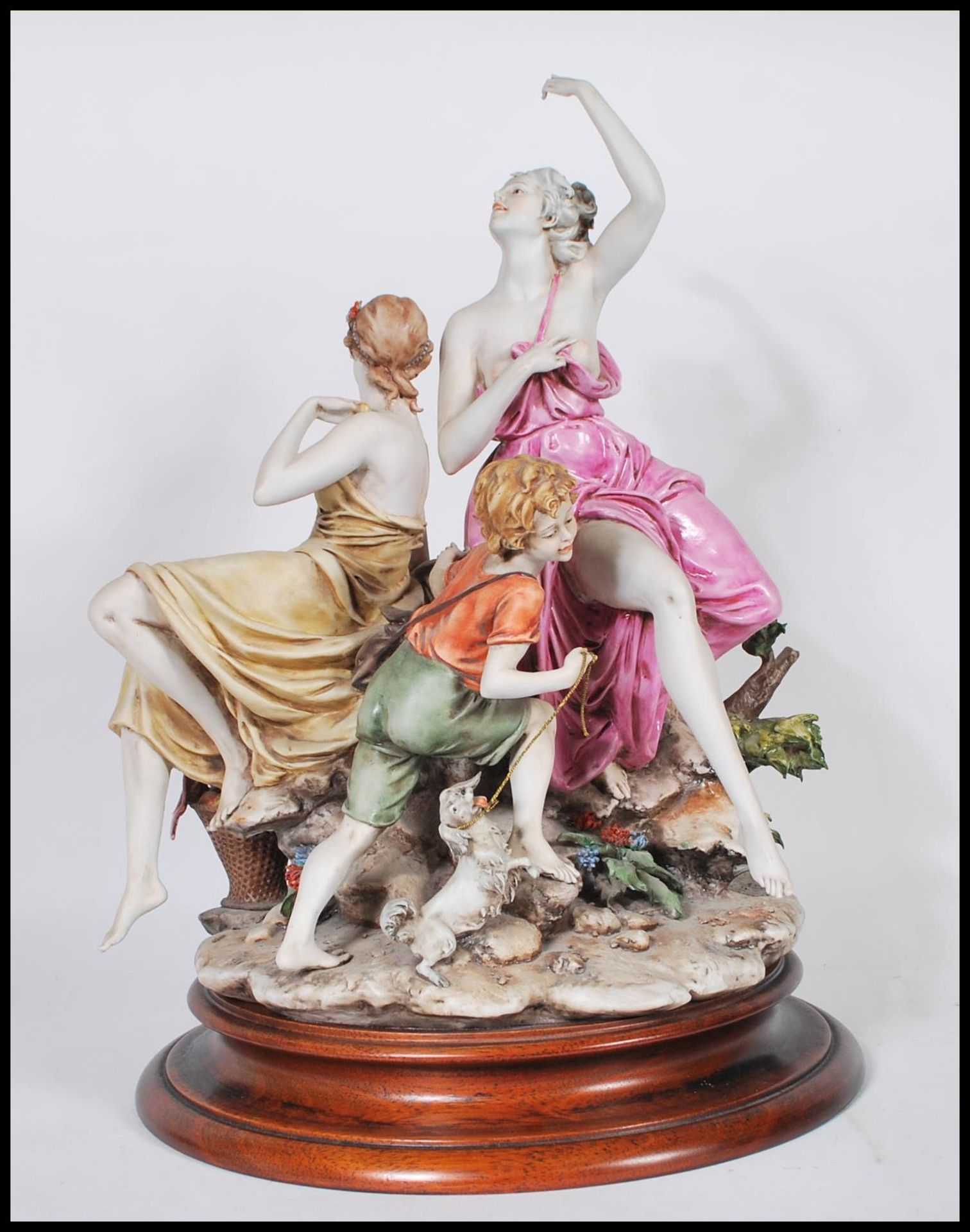 A large Capodimonte ceramic figure group depicting three figures depicting two women in draped