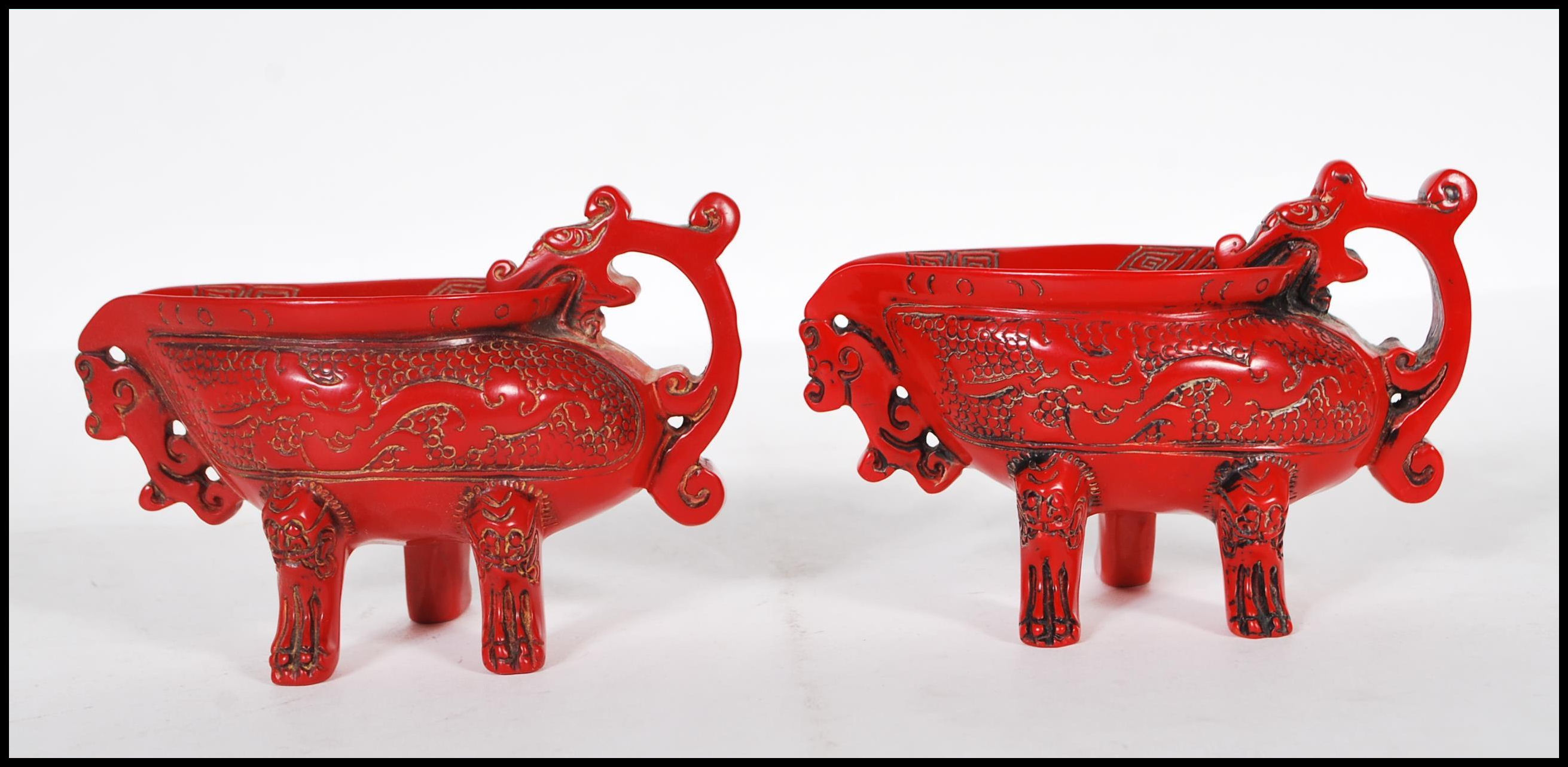 A pair of 20th Century Chinese faux Cinnabar lacquer oil pourers having scrolled decoration with