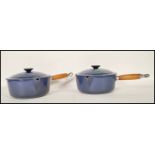 A pair of 20th Century Le Creuset lidded stove top cast iron sauce pans, each fitted with a turned