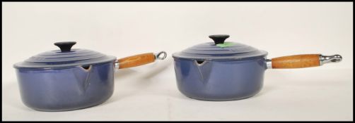 A pair of 20th Century Le Creuset lidded stove top cast iron sauce pans, each fitted with a turned