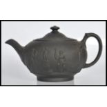 A 19th Century Victorian Wedgwood Jasperware black basalt teapot and cover having relief decorated