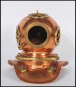 A vintage desktop model of an antique deep sea divers helmet having a copper body with brass