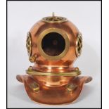 A vintage desktop model of an antique deep sea divers helmet having a copper body with brass