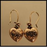 A pair of 9ct gold hallmarked heart shaped 20th Century drop earrings each with chase decorated