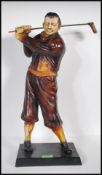 A 20th Century vintage Art Deco style resin figurine in the form of a golfer swinging a club,