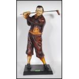 A 20th Century vintage Art Deco style resin figurine in the form of a golfer swinging a club,