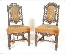 A pair of 19th Century carved oak peg jointed carolean chairs having intricately carved foliate