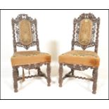 A pair of 19th Century carved oak peg jointed carolean chairs having intricately carved foliate