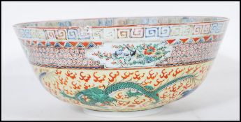 An early / mid 20th Century Chinese centrepiece bowl having a yellow ground hand painted with four