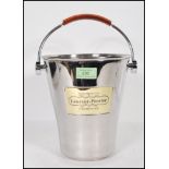 A vintage Laurent Perrier brushed steel champagne ice bucket having a leather swing handle and