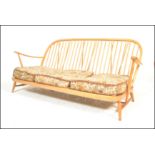 Ercol - A vintage mid 20th Century Windsor pattern three seater sofa / settee in beech and elm