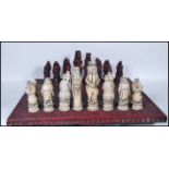 A large contemporary chess set heraldic style chess set and board in  resin with. The chess pieces