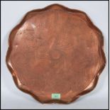 An early 20th Century Arts and Crafts Newlyn style centrepiece copper tray of round form having
