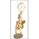 A contemporary Juliana figural pendulum quartz clock, the movement held aloft by a classical style