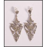 A pair of stamped 925 silver drop earrings of scro